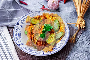 Fried Solanum melongena with Egg in a green dish on the table with garlic, dried chilli