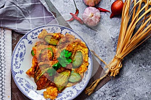 Fried Solanum melongena with Egg in a green dish on the table with garlic, dried chilli