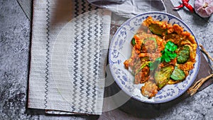 Fried Solanum melongena with Egg in a green dish on the table with garlic, dried chilli