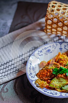 Fried Solanum melongena with Egg in a green dish on the table with garlic, dried chilli