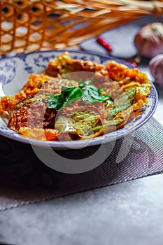 Fried Solanum melongena with Egg in a green dish on the table with garlic, dried chilli