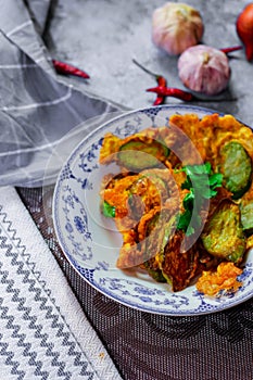 Fried Solanum melongena with Egg in a green dish on the table with garlic, dried chilli