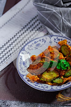 Fried Solanum melongena with Egg in a green dish on the table with garlic, dried chilli