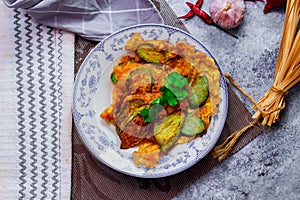 Fried Solanum melongena with Egg in a green dish on the table with garlic, dried chilli