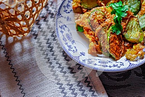 Fried Solanum melongena with Egg in a green dish on the table with garlic, dried chilli