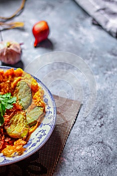 Fried Solanum melongena with Egg in a green dish on the table with garlic, dried chilli