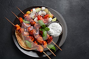 Fried souvlaki, greek salad and tzatziki on wooden table.