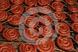 Fried spiral sausages on an electric barbecue BBQ grill. electric griddle to cook food. German Bratwurst pork sausage.