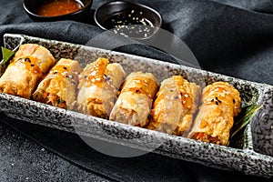 Fried spring rolls. Black background. Traditional Chinese cuisine. Top view