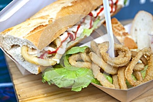 Fried squid rings displayed on bread roll and cardbox
