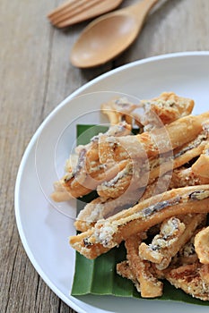 fried squid of Thai seafoods in the white dish on wood floor.