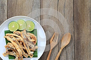 fried squid of Thai seafoods in the white dish on wood floor.