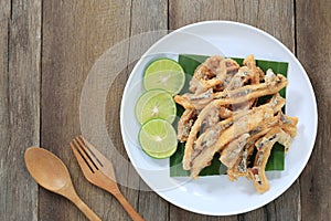 fried squid of Thai seafoods in the white dish on wood floor.