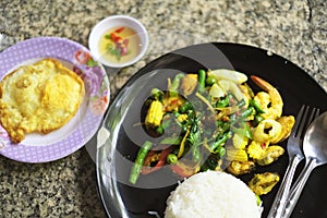 Fried stir spicy sea food with steamed rice and fried egg