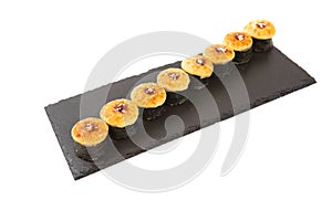 Fried sushi roll on a black slate surface, menu concept. Isolated on white