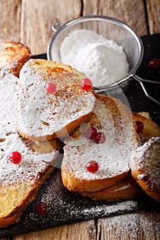 Fried sweet toast with sugar powder and cranberries close-up. vertical
