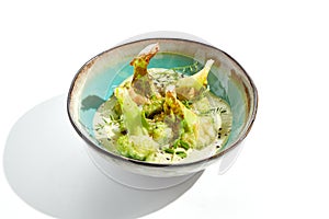 Fried tempura broccoli with peanut sauce in bowl. Vegeterian hot dish - florets cabbages roasted  in klar on white background.