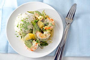 Fried tiger prawn shrimp dish with sugar peas, onion, oranges and rice, high angle view from above, copy space