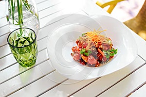 Fried tofu with sesame seeds and vegetables on a white plate