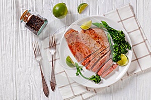 Fried tuna steak with boiled broccolini and lime