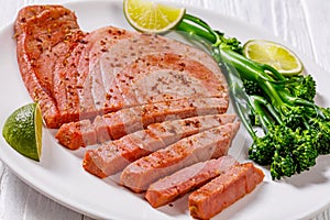 Fried tuna steak with boiled broccolini and lime