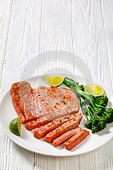 Fried tuna steak with boiled broccolini and lime