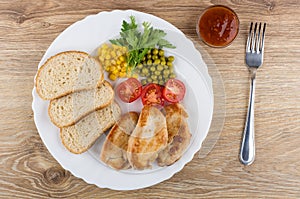 Fried turkey meat with vegetables, bread in dish, ketchup