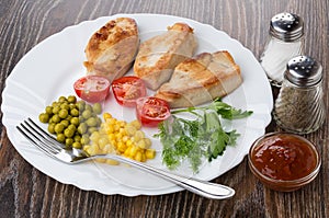 Fried turkey meat with vegetables in dish, salt, pepper, ketchup