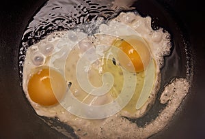 Fried two eggs in a frying pan close up