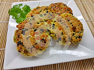 Fried vegetable flat cake on the white square plate