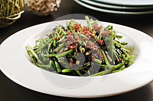 Fried vegetables of the morning glory or rau muong on white plat
