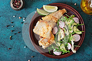 Fried white fish fillet and cucumber and radish salad.