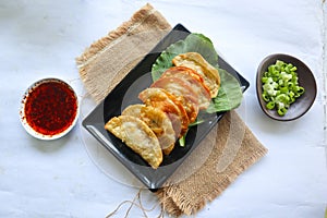 fried wonton. wonton on plate with chili oil. Shrimp or meat dumplin,g soup with mustard , green onions, on white background