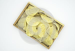 Fried yellow potato chips In wooden tray isolated on white background of file with Clipping Path