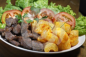 Fried yucca, meat and salad