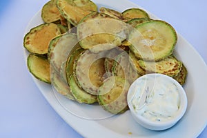 Fried zucchini chips with tzatziki Greek tavern plate. photo