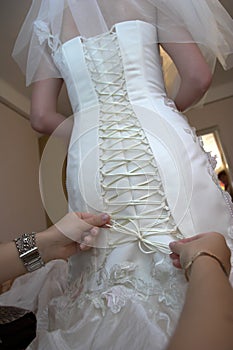 Friend of the bride bride corset laces on a wedding dress