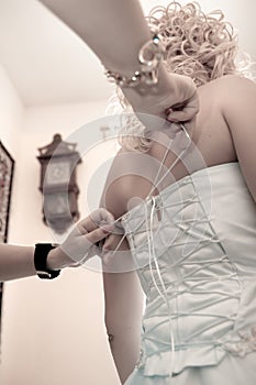 Friend of the bride bride corset laces on a wedding dress