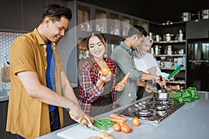 friend cooking together in the kitchen while looking at online course from tablet pc