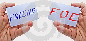 Friend or foe signs on cards in man hands with a white background. for business concepts