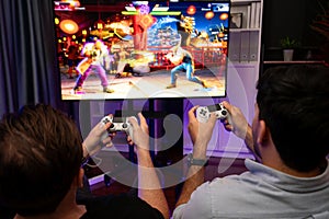 Friend gamers playing video game of battle martial arts fighter. Sellable.