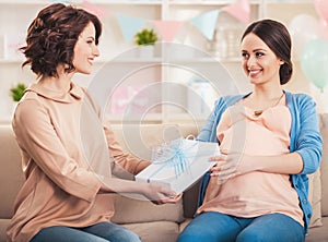 Friend Giving to Pregnant Woman Gift in Blue Box.