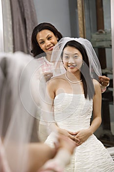 Friend helping bride.