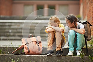 Friend Helping Sad Little Girl in School photo