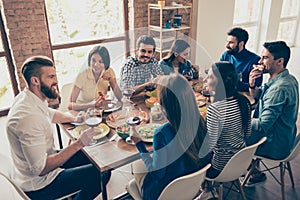 Friend`s gathering for feast. Cheerful youth is having tasty foo