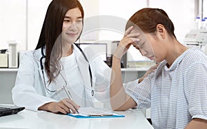 Friendly Asian doctor with smiley face, touching stress patient on shoulder for soothe with gently calm in medical consultation