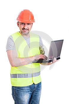 Friendly attractive engineer holding and working on laptop