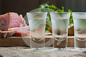 Friendly booze - three glasses of vodka on the table on the background of snacks