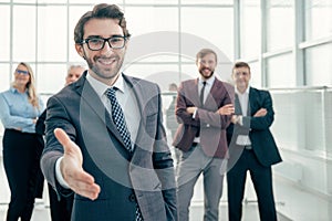 Friendly businessman holding out his hand for a handshake