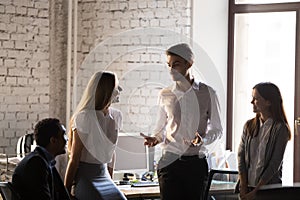 Friendly businessman joking with diverse colleagues during break